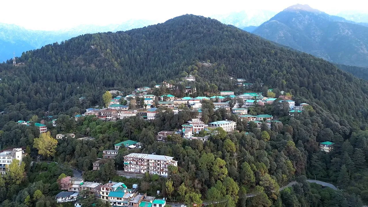 Aerial view of McLeod Ganj town on a forested hill above Dharamshala