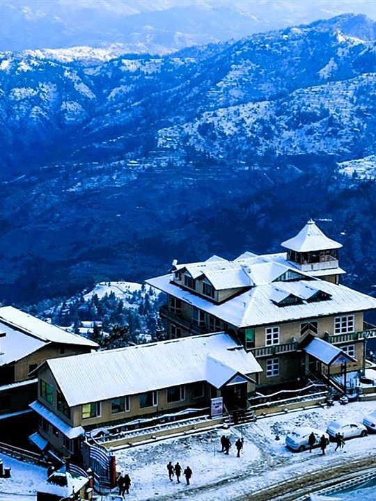 Snow-covered hill hotel overlooking a mountain valley in winter