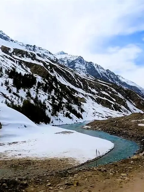Snow-covered mountains and a winding river valley in Himachal Pradesh