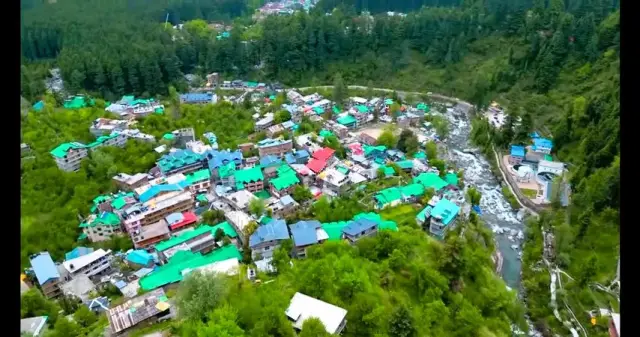 Aerial view of a riverside mountain village with colourful roofs in Himachal