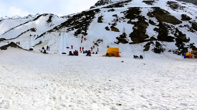 Tourists playing on snow slopes at a snow point near Manali