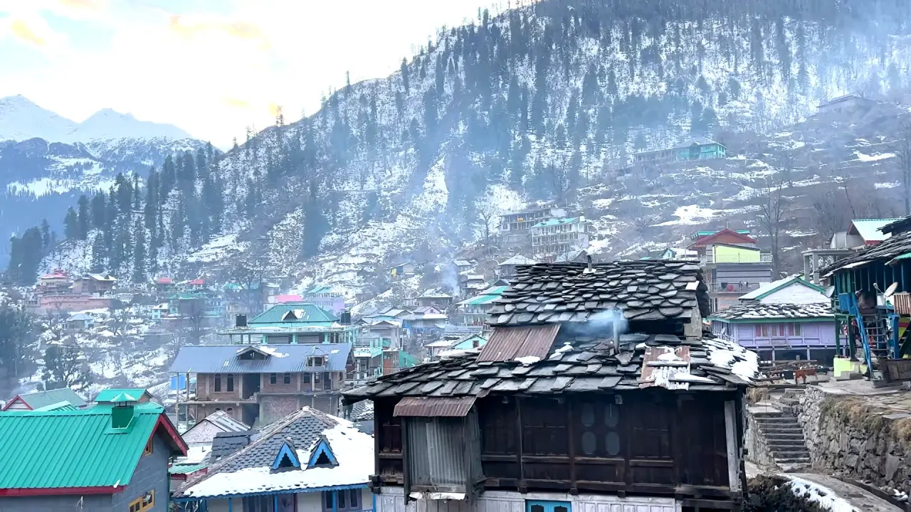 Old wooden slate-roofed houses in a snowy Parvati Valley village
